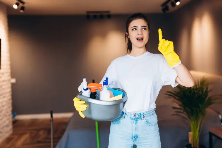 young-woman-holding-cleaning-supplies-pointing-up.jpg
