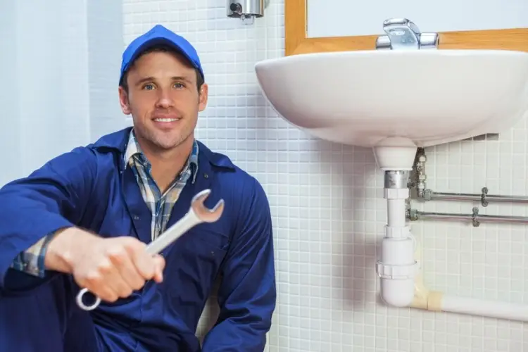 happy-plumber-holding-wrench-sitting-sink_13339-253882.jpg