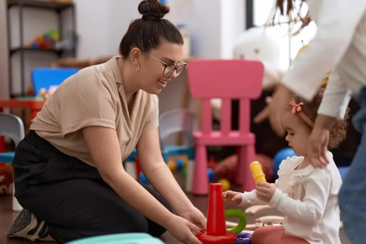 toddler-learning-with-daycare-worker-in-playroom.jpg