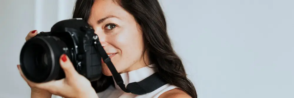 female-photographer-holding-camera-smiling.jpg