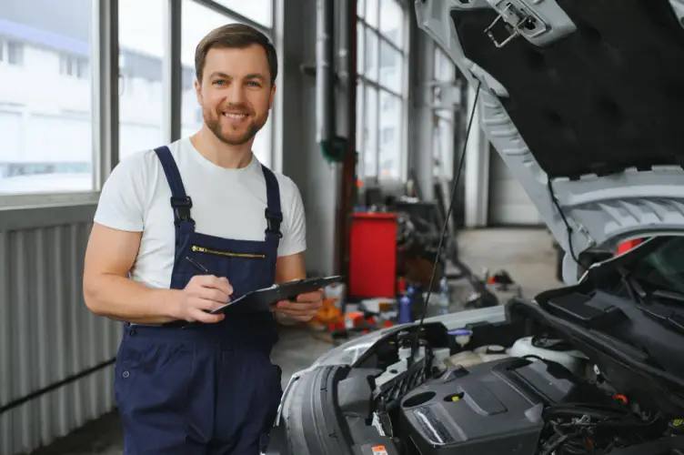 auto-mechanic-smiling-holding-clipboard-car-repair-workshop.jpg