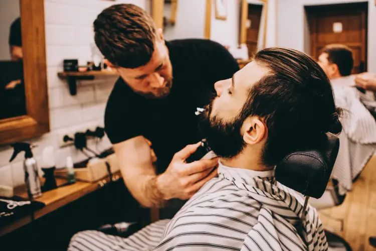 barber-trimming-client-beard-in-chair.jpg