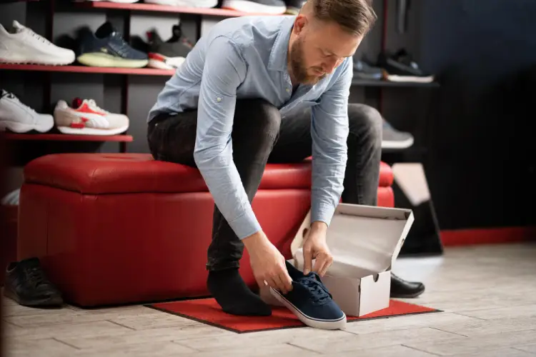 man-trying-on-sneakers-in-shoe-store.jpg