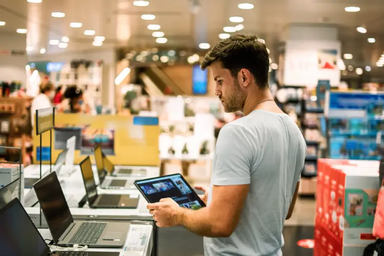 man-evaluating-tablets-in-electronics-store.jpg