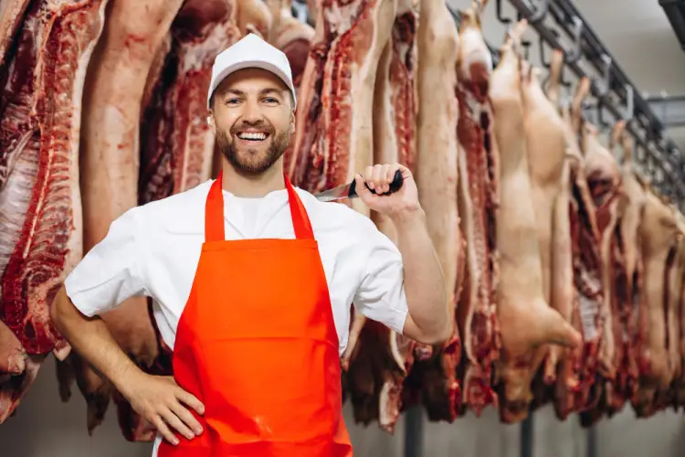smiling-butcher-in-red-apron-meat-room.jpg