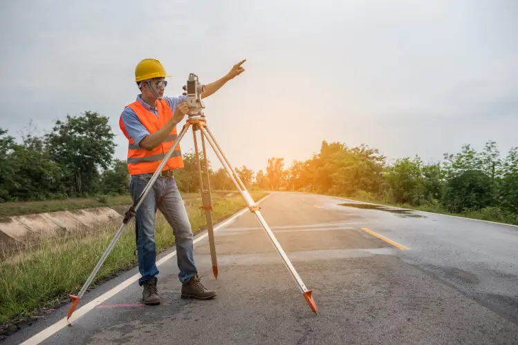 surveyor-using-theodolite-while-working-road-against-sky.jpg