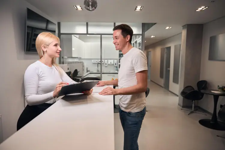 receptionist-handing-clipboard-to-customer.jpg