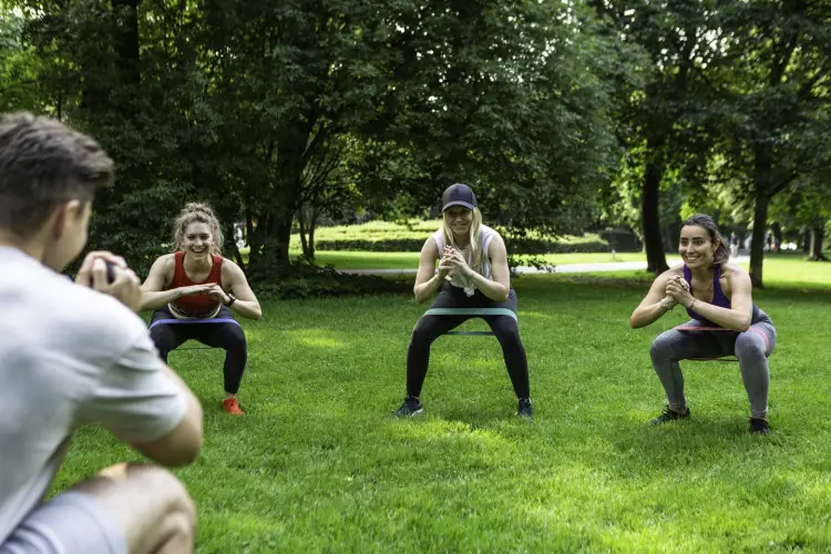 three-ladies-practice-squats-park-with-their-fitness-instructor.jpg