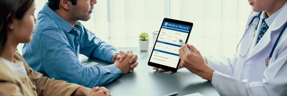 doctor-showing-medical-record-to-patient-couple.jpg