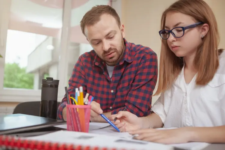 teacher-assisting-girl-homework.jpg