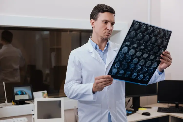 typical-workdays-serious-handsome-experienced-radiologist-holding-mri-scan-photo-examining-it-while-working-lab.jpg