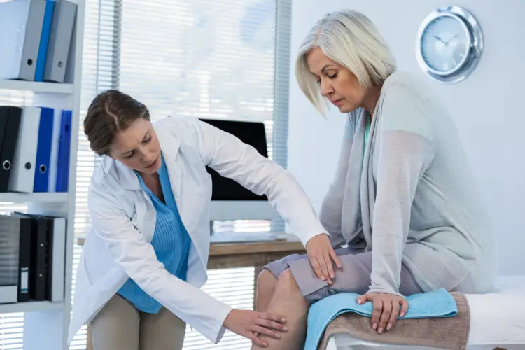 doctor-examining-womans-knee-pain.jpg