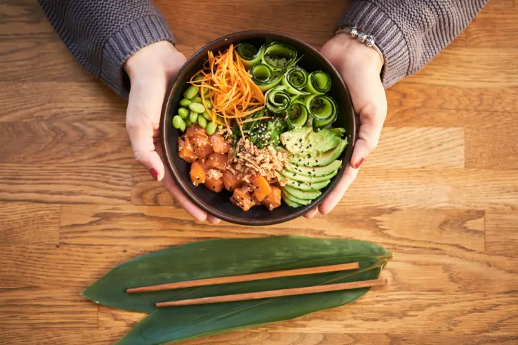 hands-holding-poke-bowl-with-avocado-edamame-cucumber.jpg