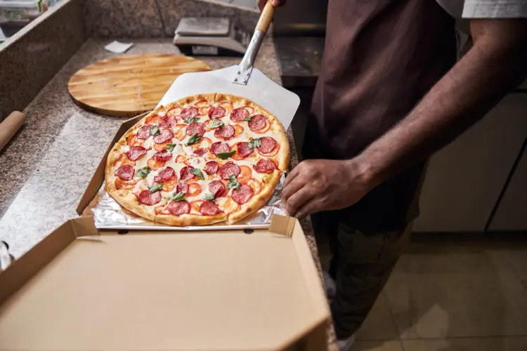 placing-pepperoni-pizza-into-takeout-box.jpg